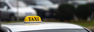 A car with a taxi sign stands during the da