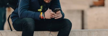 Adam bankta otururken telefonda oturuyor.