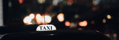 A car with a taxi sign stands at nigh