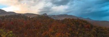 Forest and mountain peaks in autumn under the cloud