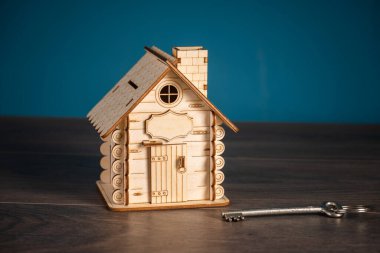 Yanında anahtar olan dekoratif ahşap bir ev.
