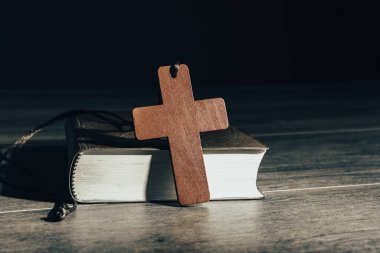 Kutsal İncil ve tahta haç masanın üstünde.