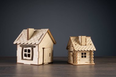 Gri arka planda ahşap evler, ev satın alma ve satış konsepti