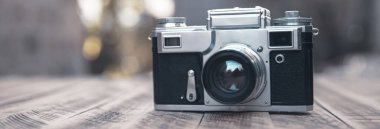 Ahşap bir masanın üzerinde klasik bir kamera.