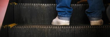 İnsanlar bir binada yürüyen merdivende duruyorlar.