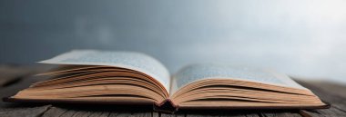 Tahta masanın üzerinde açık bir kitap!
