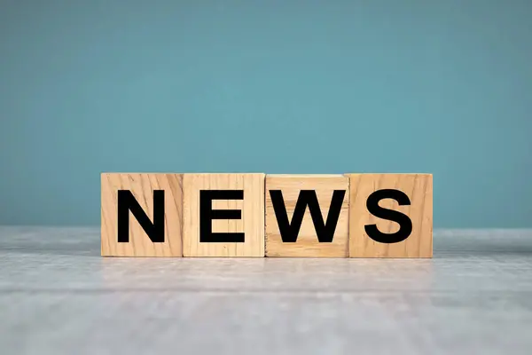 Mavi stüdyonun arka planında, tahta küplere yazılmış haberler.: