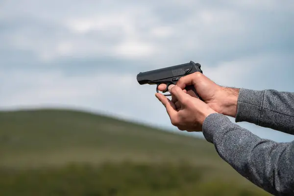 Man holding gun, nature scene in background
