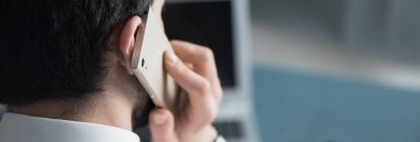 Konuşan adam ofiste çalışıyor.