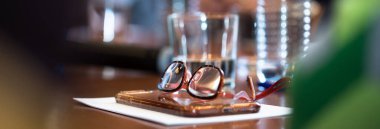 Bardaklar ve kağıtlar konferans salonunda masanın üzerinde.