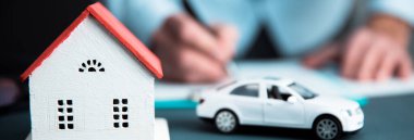 Evi ve arabası olan bir adam.