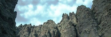 Gökyüzünün altında çimen olan yüksek uçurumlar