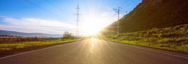 Gün batımlı ve yeşil çimenli yol