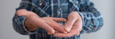 Gri duvarda ağrıyan bir adam parmağı var.