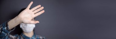 Kadın yüz maskesi ve el duruşu işareti gri sırtüstü