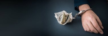 Masada para olan kelepçeli bir adam.