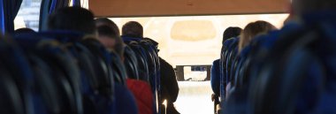 İnsanlar gün batımında otobüse binerler.