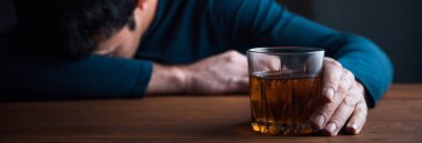 Hüzünlü adam, masanın üzerinde bardak içkisi var.