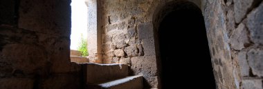 Binanın arkasında eski karanlık bir taş var.