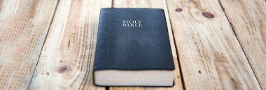 Kutsal İncil ahşap masanın üstünde.