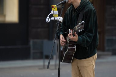 Gitarist, sokak müzisyeni oyunları, para kazanıyor, şehir sokakları.