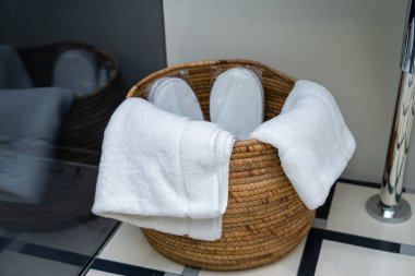Saman sepetinde beyaz havlular, otel servis konsepti.