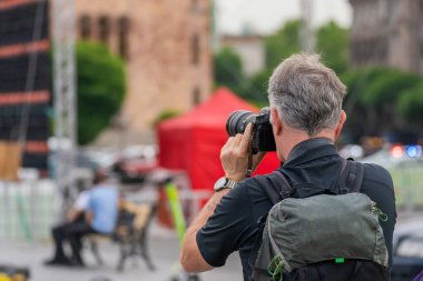 Bir turist şehirde fotoğraf makinesiyle fotoğraf çeker.