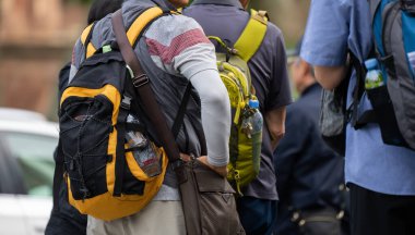 Sırt çantalı insanlar karşıdan karşıya geçiyor.