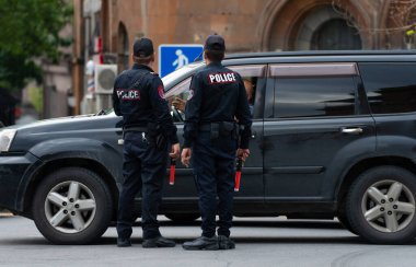 Polis memurları arabayı kontrol ediyor, resmi çalışma süreci.