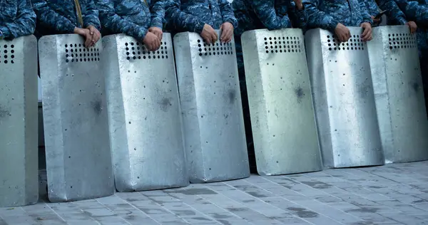 stock image Policemen protect themselves from demonstrators with their shields, protest