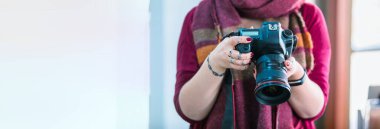 Genç kadın profesyonel fotoğrafçı el kamerası.