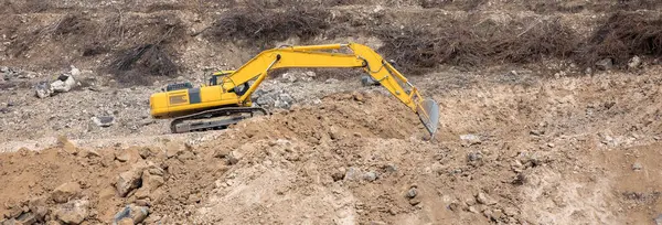 Güneşli bir günde endüstriyel makineyle çakıl ocağı kazma sahası