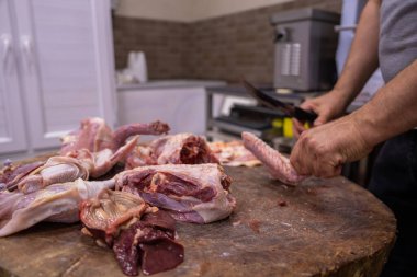 Butcher cuts meat with knife, food concept clipart