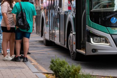 İnsanlar ulaşım aracı olarak otobüsü kullanıyor. otobüs durağı