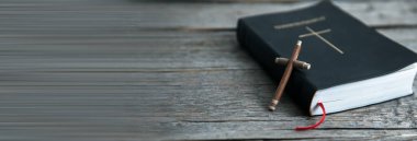 Ahşap haç ve ahşap masada İncil.