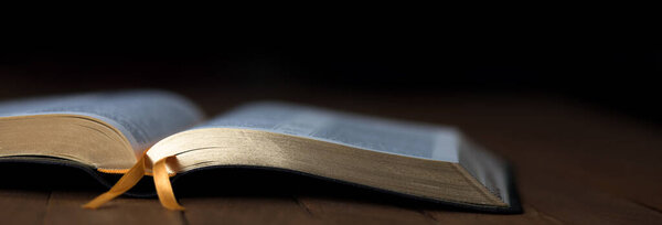 Библия на столе в темной комнате