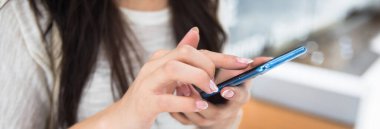 Kadın el ele tutuşup akıllı telefon kullanıyor.