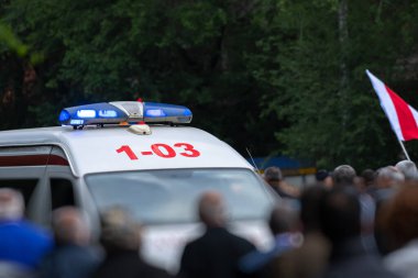 Kalabalığın içinde bir protesto, bir ambulans görüldü.