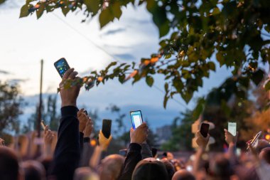 İnsanlar şehirde protesto sırasında telefonla fotoğraf çekiyor, siyasi ayaklanma