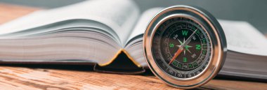 Pusula ve kitap masanın üstünde.