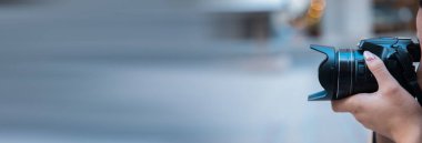 Elinde kamera olan genç bir kadın.