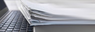 Gazeteler ve laptop. Bilgisayarda haberlerle dolu günlük kağıtlar.