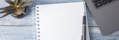 Bilgisayar ve çiçekli not defteri çalışma masasında!