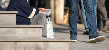 Dilenci yaşlı kadın sokakta para dileniyor.