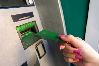 Kartı olan kadın, ATM kullanıyor.