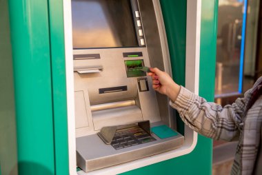 Kartı olan kadın, ATM kullanıyor.