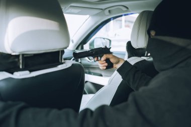 Silahlı ve maskeli bir soyguncu arabanın içindeki kadın sürücüye saldırdı.
