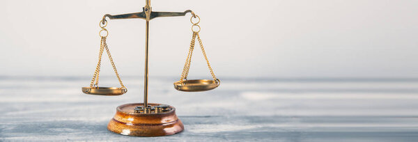 Весы правосудия на столе на серой спинке