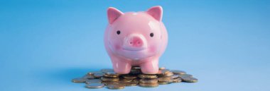 Mavi masanın üzerinde bozuk paralar olan kumbara.