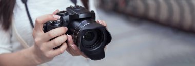 Sokakta kamera tutan genç bir kadın.